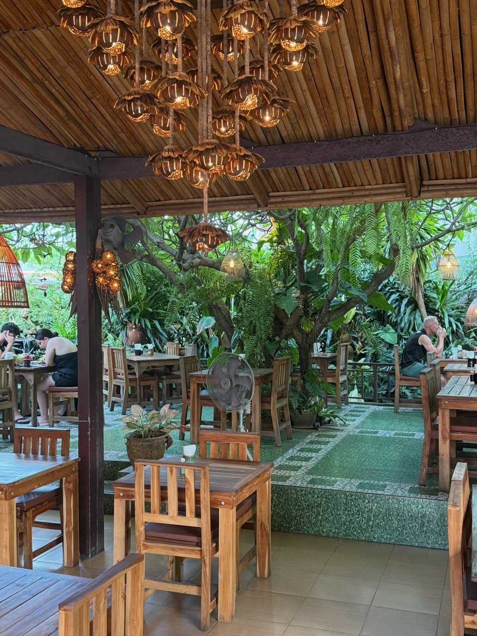 The garden pavilion in the afternoon, open to the trees on three sides.